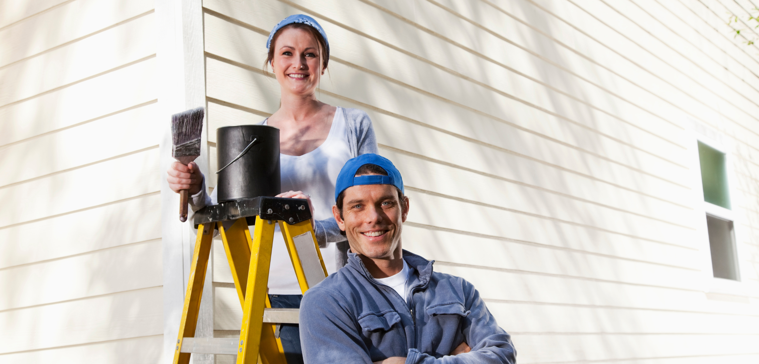 Couple painting the exterior of their home